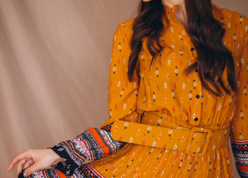 Young woman in a beautiful yellow dress in studio