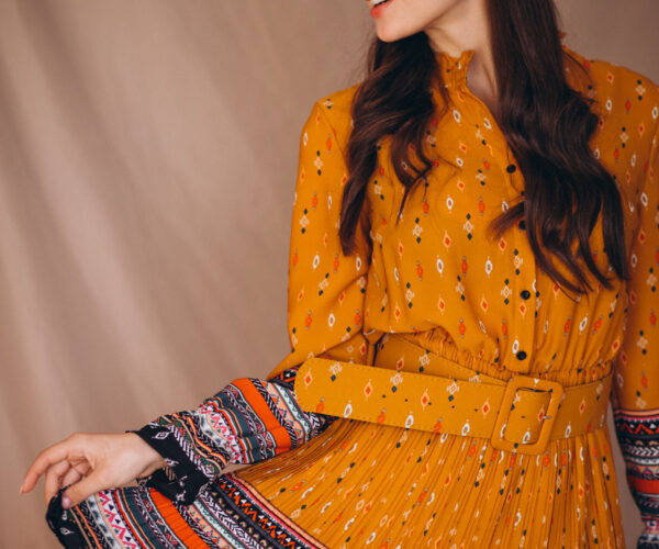 Young woman in a beautiful yellow dress in studio